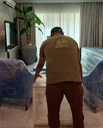 عامل يقوم بنقل الاثاث بعد تغليفه